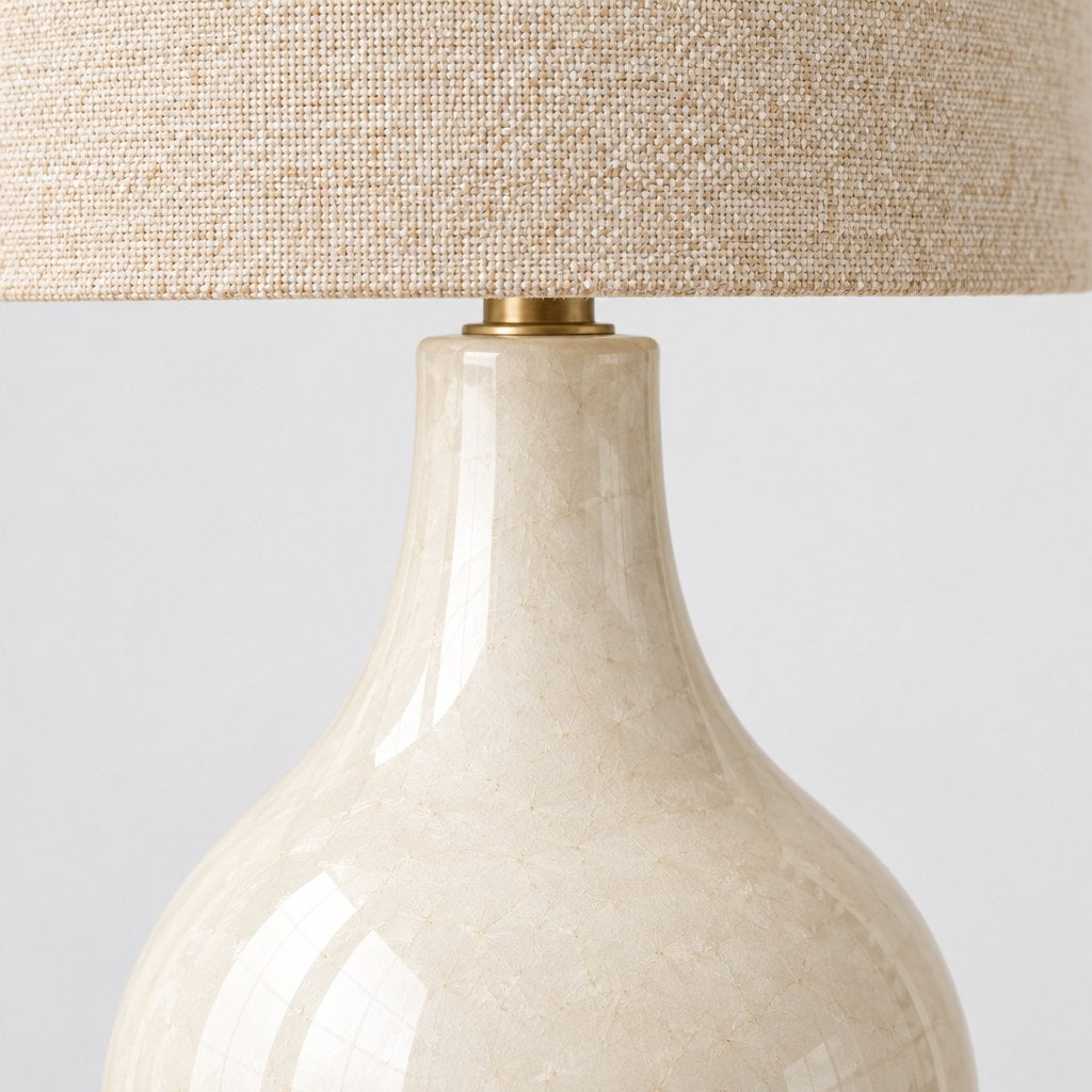 Close up of the cream ceramic base and linen shade of the Mara table lamp