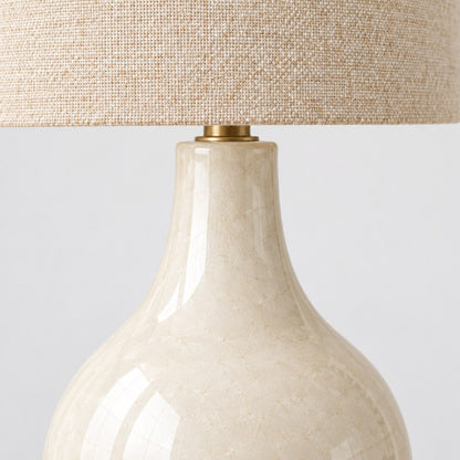 Close up of the cream ceramic base and linen shade of the Mara table lamp